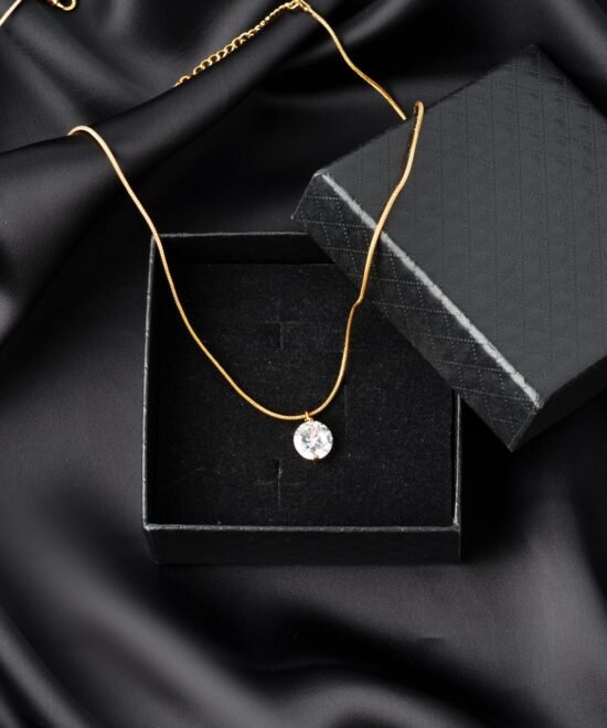 Golden necklace on silk texrtile background close up