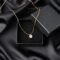 Golden necklace on silk texrtile background close up